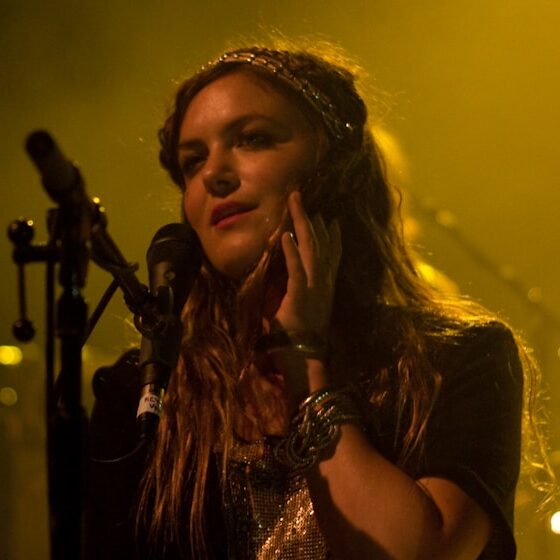 woman in black sleeveless top singing on stage